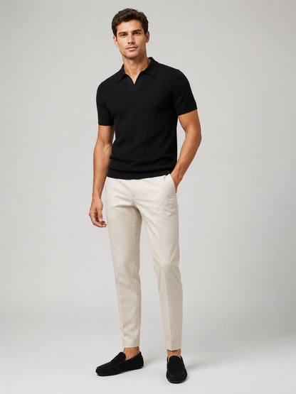 Ganzkörperfoto von vorne: schwarzes Strick-Poloshirt, helle Hose und schwarze Wildleder-Loafer vor grauem Studiohintergrund 8