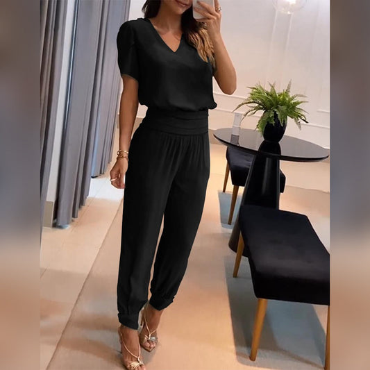 Frau in schwarzem Jumpsuit, elegantes Design, V-Ausschnitt, Wohnzimmer, Mode, Damenbekleidung.