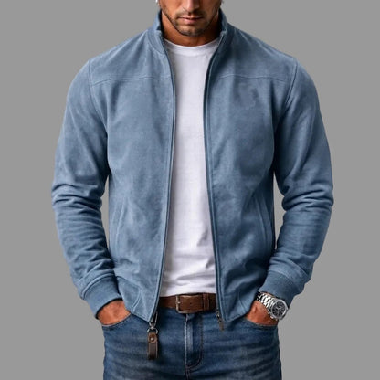 Mann trägt die hellblaue Jacke in Wildlederoptik offen über weißem T-Shirt und Jeans, Lederanhänger am Reißverschluss. 4