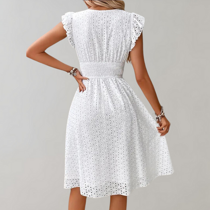Frau in weißem Spitzenkleid mit Rüschenärmeln, Sommermode, elegantes Design, Rückansicht.