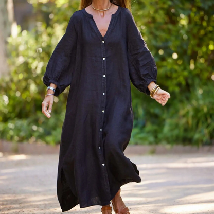 Frau in schwarzem Leinenkleid mit Knopfleiste, lange Ärmel, Sommermode, draußen.