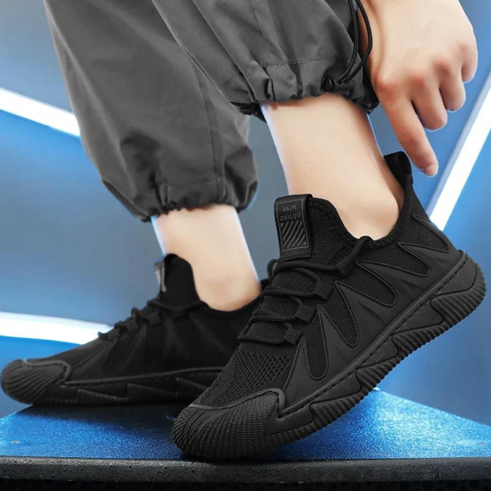 Schwarze Sneaker für Herren, atmungsaktiv, sportlich, rutschfest, modisch, auf blauem Hintergrund.