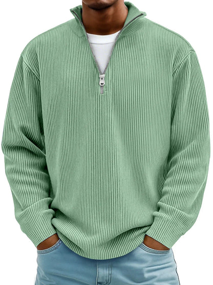 Mann trägt den gerippten Pullover in Mintgrün mit Stehkragen und Reißverschluss, kombiniert mit heller Jeans 3