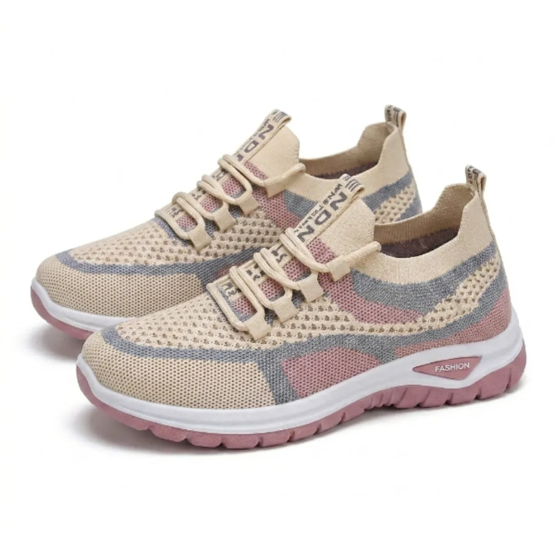 Paar beige Mesh-Sneaker mit rosa und blaugrauen Akzenten und rosa Sohle, schräg von der Seite auf weißem Hintergrund. 34