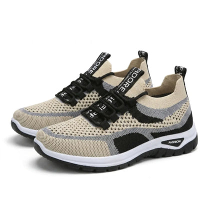 Paar beige Mesh-Sneaker mit grauen und schwarzen Akzenten, schwarzen Schnürsenkeln und weißer Sohle, schräg von vorn auf weißem Hintergrund. 43