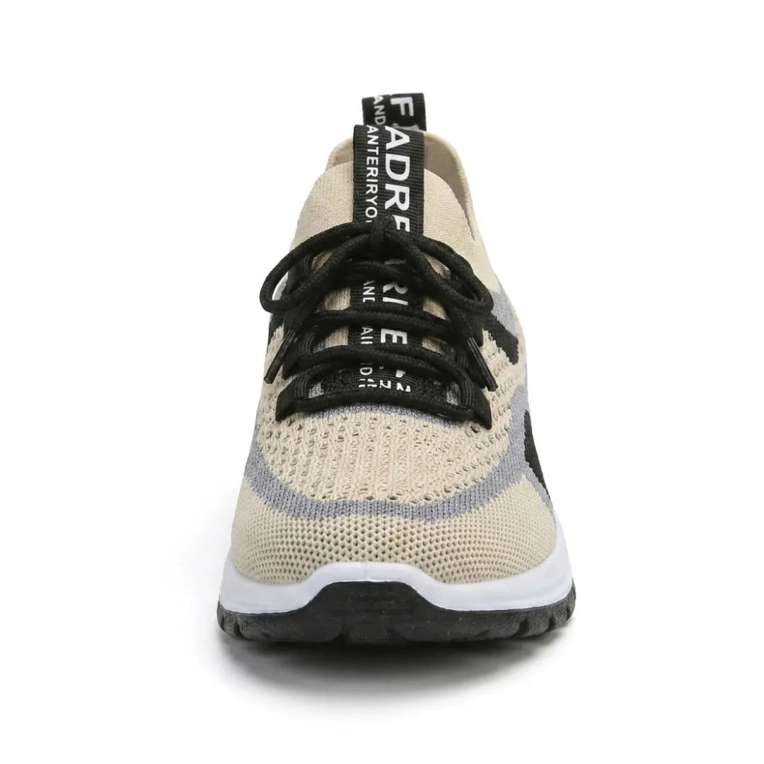 Frontansicht eines beigen Sneakers aus atmungsaktivem Strickmesh mit schwarzer Schnürung, grauen Streifen, breiter Spitze und weiß-schwarzer Sohle. 44
