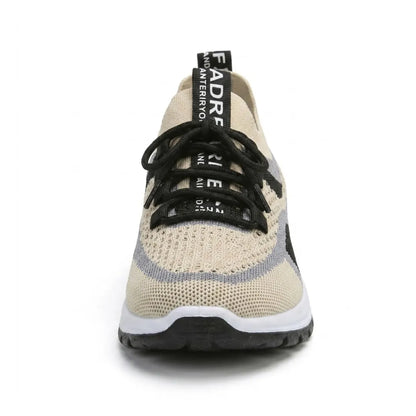 Frontansicht eines beigen Sneakers aus atmungsaktivem Strickmesh mit schwarzer Schnürung, grauen Streifen, breiter Spitze und weiß-schwarzer Sohle. 44