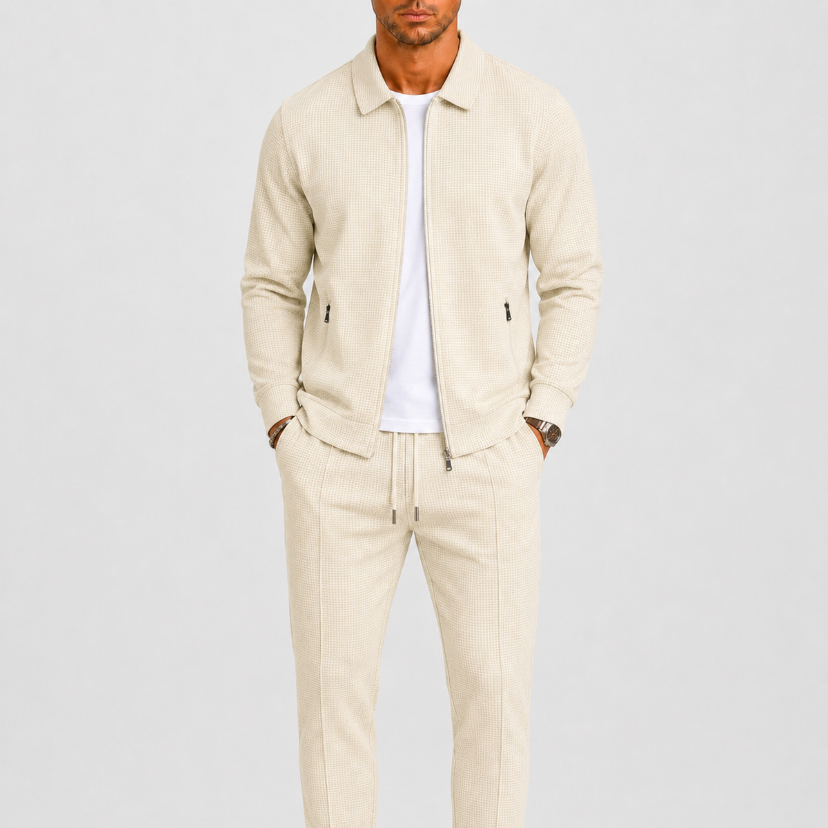 Model trägt das beige Set mit offener Waffelstrick-Jacke über weißem T-Shirt, Hände in den Taschen 1