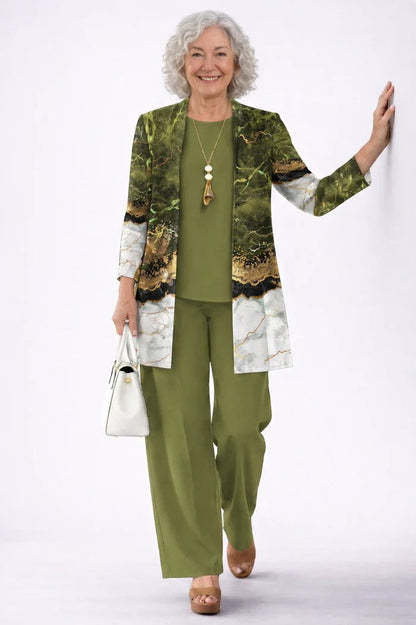 Lächelnde Frau in Grün lehnt an einer Wand, Cardigan im Marmor-Look mit Goldadern, Top und Hose 12