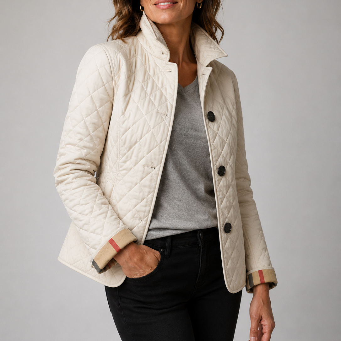 Cremefarbene Steppjacke mit karierten Manschetten, Hand in der Jeanstasche, getragen über grauem Shirt und schwarzer Hose 6