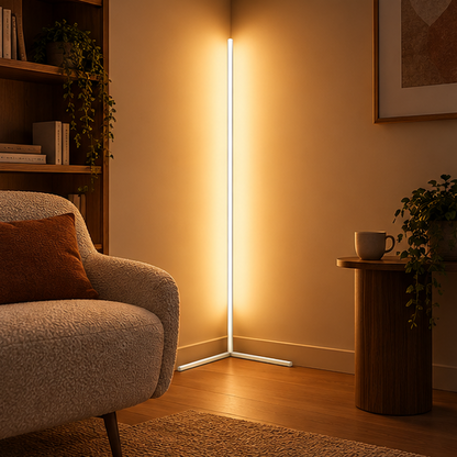 Weiße Eck-Stehlampe leuchtet warm in einer Zimmerecke neben Sessel, Bücherregal und rundem Beistelltisch mit Tasse. 2