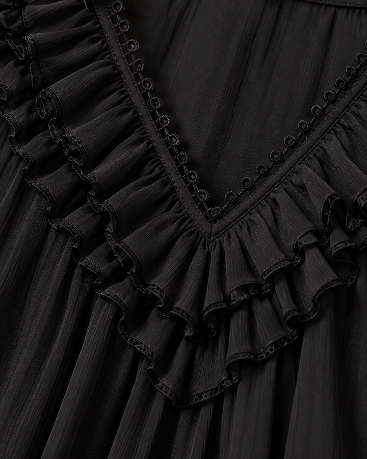 Nahaufnahme des V-Ausschnitts in Schwarz mit gekräuselten Rüschen, feinem Chiffon-Stoff und einer Borte aus kleinen Ösen. 5