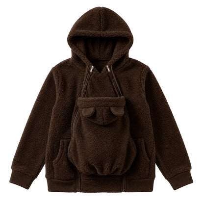 Dunkelbrauner Sherpa-Hoodie als Flat Lay mit eingesetztem Babytrageeinsatz, Bärenöhrchen, Doppelreißverschlüssen und Seitentaschen. 14