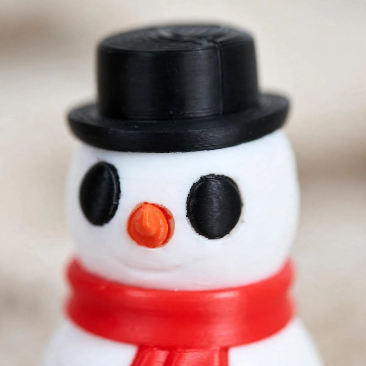 Nahaufnahme einer Schneemann-Figur mit schwarzem Zylinder, schwarzen Augen, orangeroter Nase und rotem Schal 3