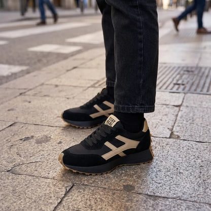 Schwarz-beige Sneaker, getragen zu dunkler Jeans auf hellem Steinboden in der Stadt 17
