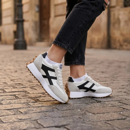 Sneaker getragen von einer Frau mit schwarzer Jeans und weißen Socken auf Kopfsteinpflaster 22