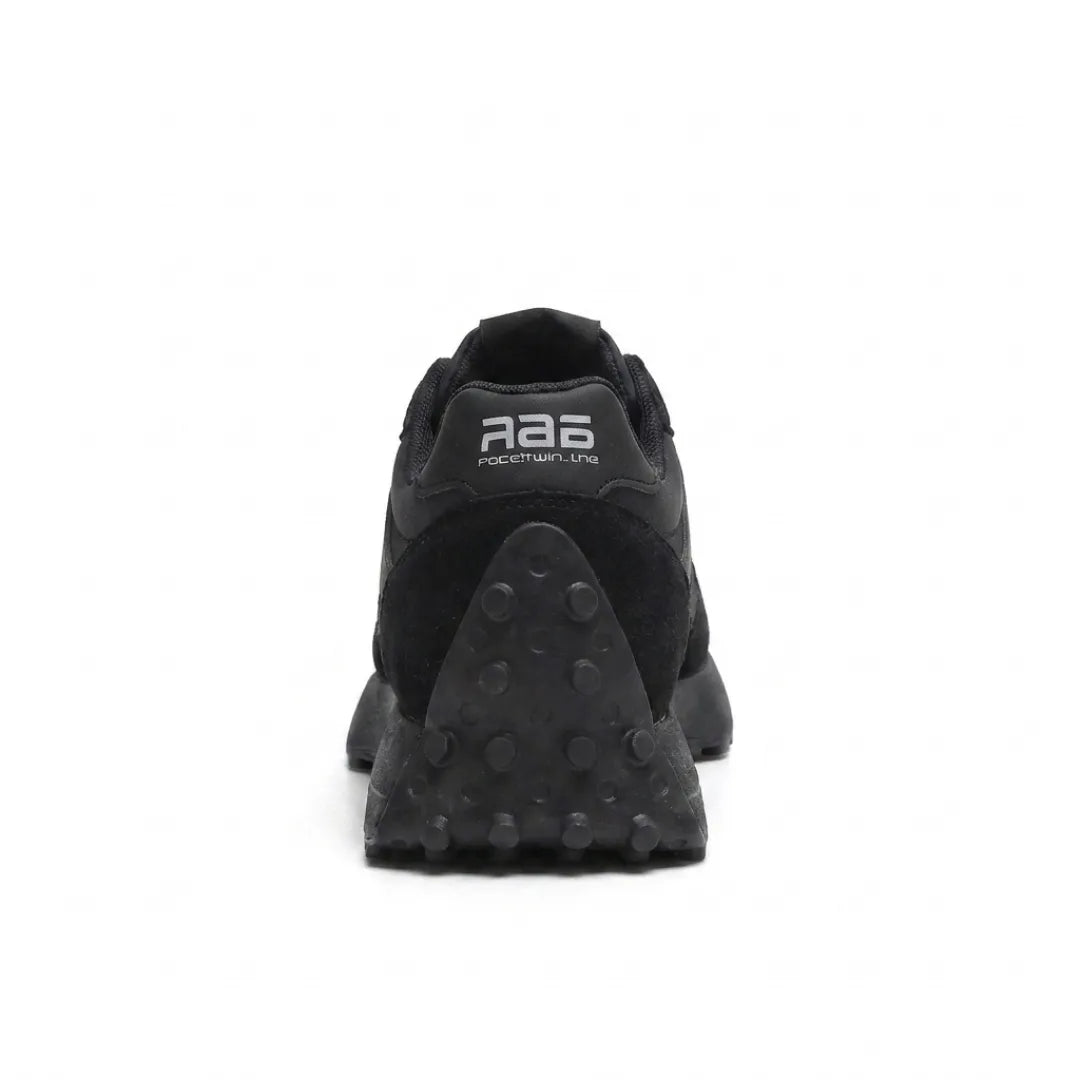 Schwarzer Sneaker von hinten mit Fersenlasche und dreieckiger Noppensohle 10