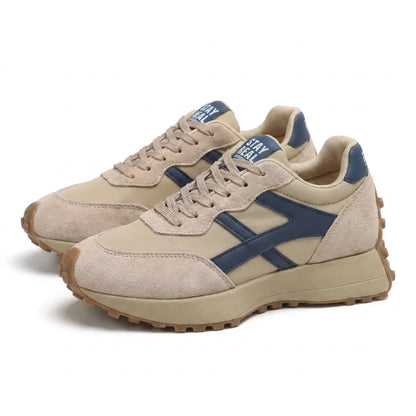 Beiges Sneaker-Paar mit blauen Akzenten in Schrägansicht, Plateausohle mit Noppenprofil 3