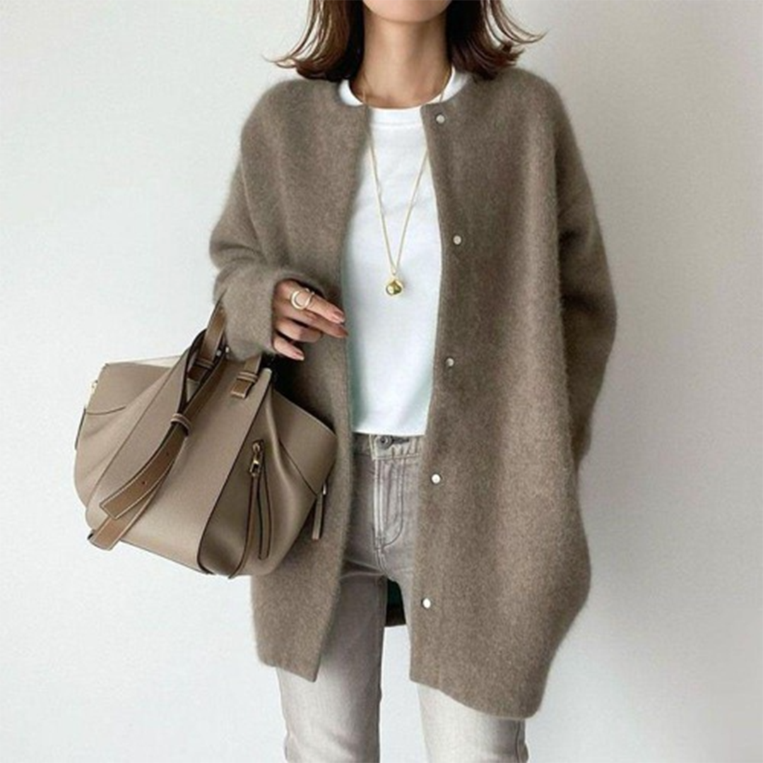 Frau trägt die flauschige Strickjacke in Graubraun mit Druckknöpfen zu weißem Shirt und heller Jeans 7