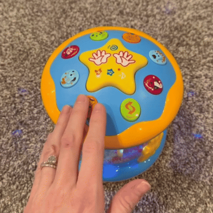 Buntes, drehbares Babyspielzeug mit Lichtern auf Teppichboden, interaktive Lernhilfe.