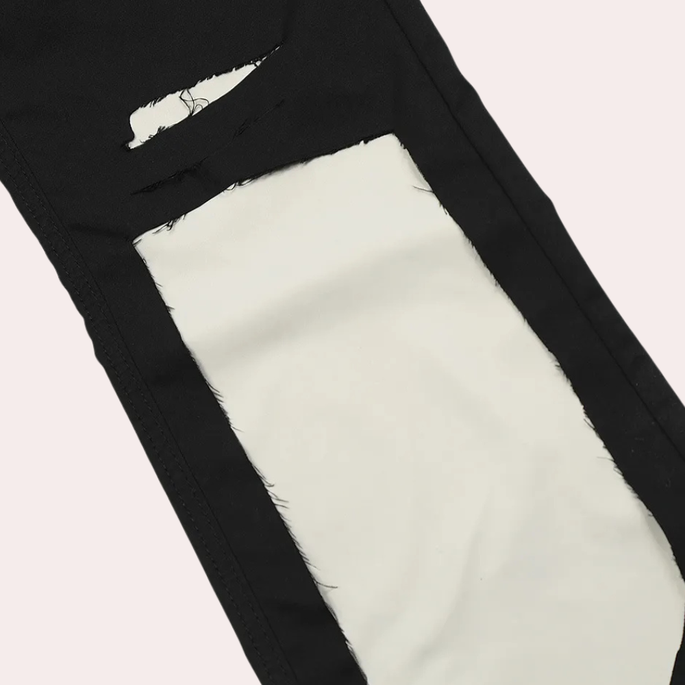 Schwarze Jeans mit weißem, rechteckigem Riss-Detail, modische zerrissene Denim-Hose.