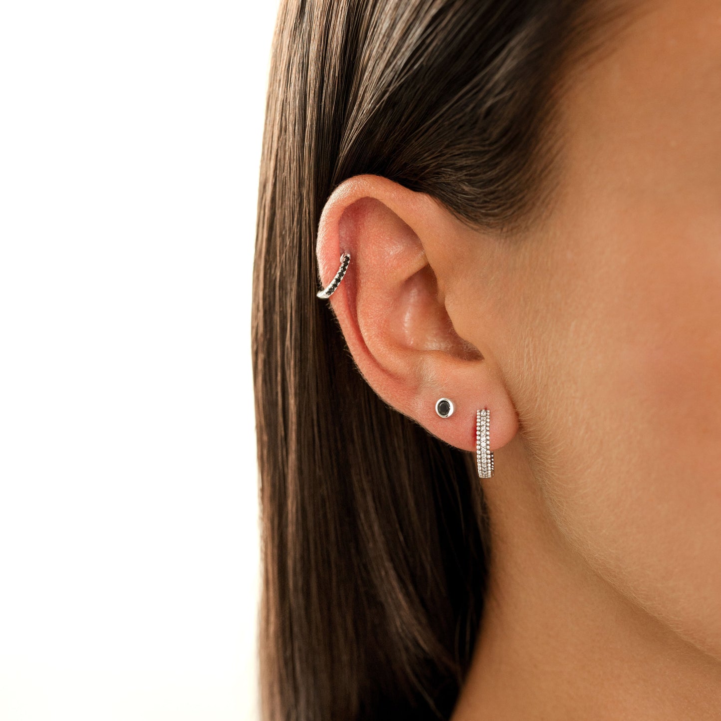Frau mit silbernen Ohrringen, Helix-Piercing, glattes Haar, Nahaufnahme, Schmuckmode.