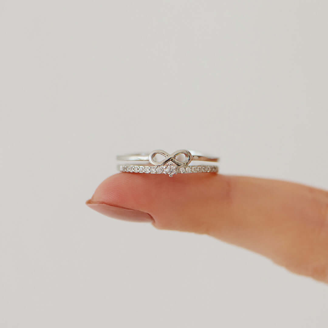 Silberner Unendlichkeitsring mit Diamanten auf Finger, eleganter Schmuck, Verlobungsring.