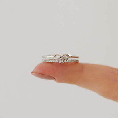Silberner Unendlichkeitsring mit Diamanten auf Finger, eleganter Schmuck, Verlobungsring.