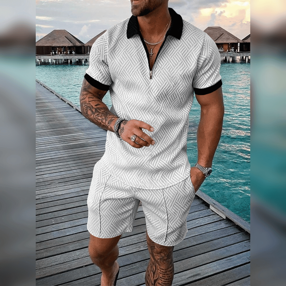 Mann in weißem Sommer-Set mit Muster, schwarzem Kragen, auf Holzsteg am Meer.