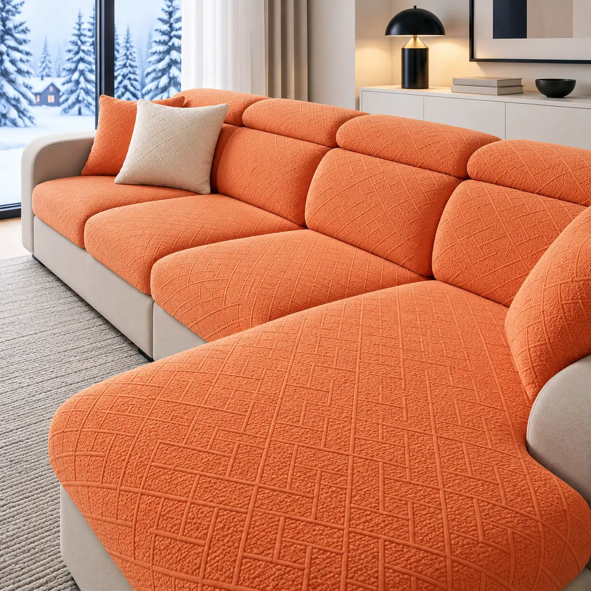 Orangefarbene Sofabezüge mit Rautenmuster auf einem Ecksofa im Wohnzimmer mit Blick auf Schneelandschaft 1