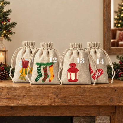Vier Jutesäckchen mit Kordelzug und weihnachtlichen Motiven stehen weihnachtlich dekoriert auf einem rustikalen Holzregal neben Tannenzweigen und Kerzenlicht. 1