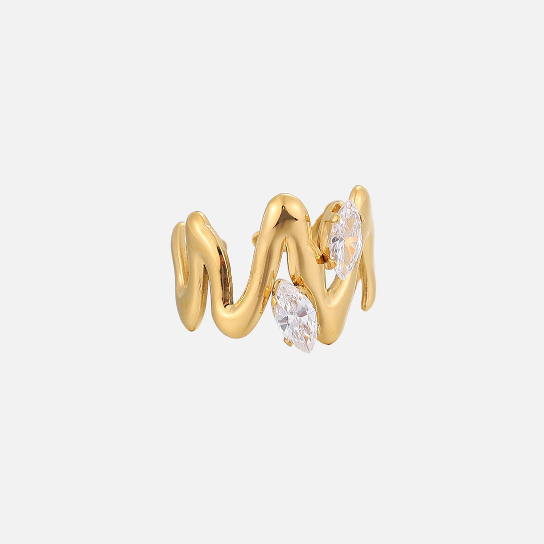 Seitenansicht des goldfarbenen Rings mit fließend geschwungenem Band und zwei klaren, spitzovalen Steinen auf hellgrauem Hintergrund. 2