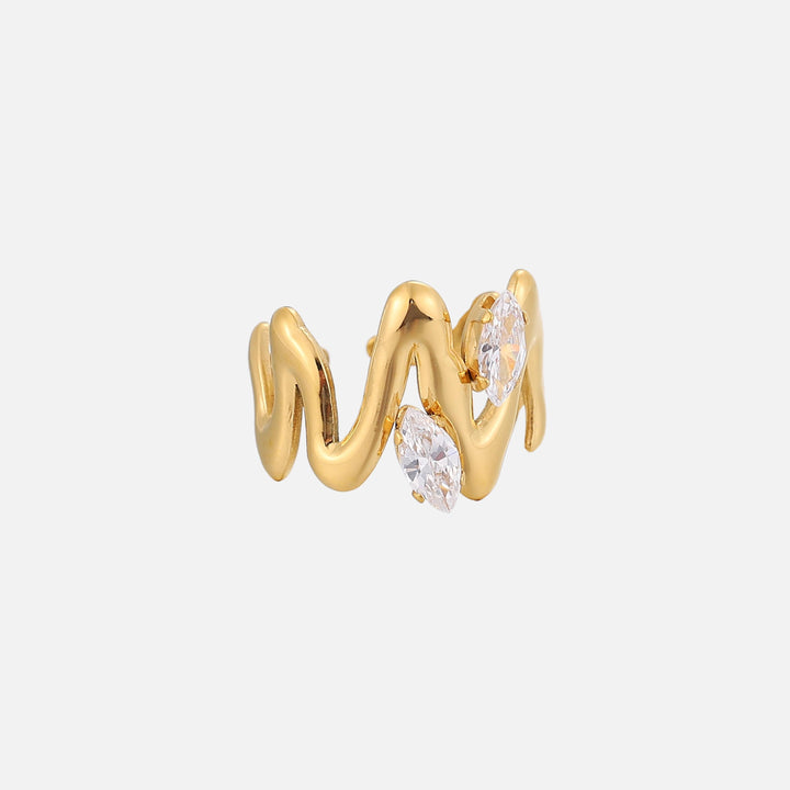 Seitenansicht des goldfarbenen Rings mit fließend geschwungenem Band und zwei klaren, spitzovalen Steinen auf hellgrauem Hintergrund. 2