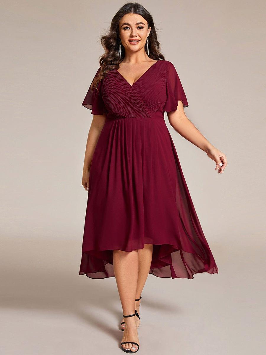 Plus-Size-Model im weinroten Kleid mit langen Ohrringen und schwarzen Sandaletten, Vorderansicht im Gehen. 49