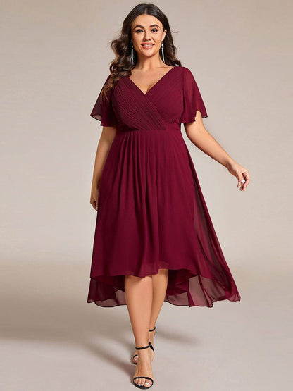 Plus-Size-Model im weinroten Kleid mit langen Ohrringen und schwarzen Sandaletten, Vorderansicht im Gehen. 49