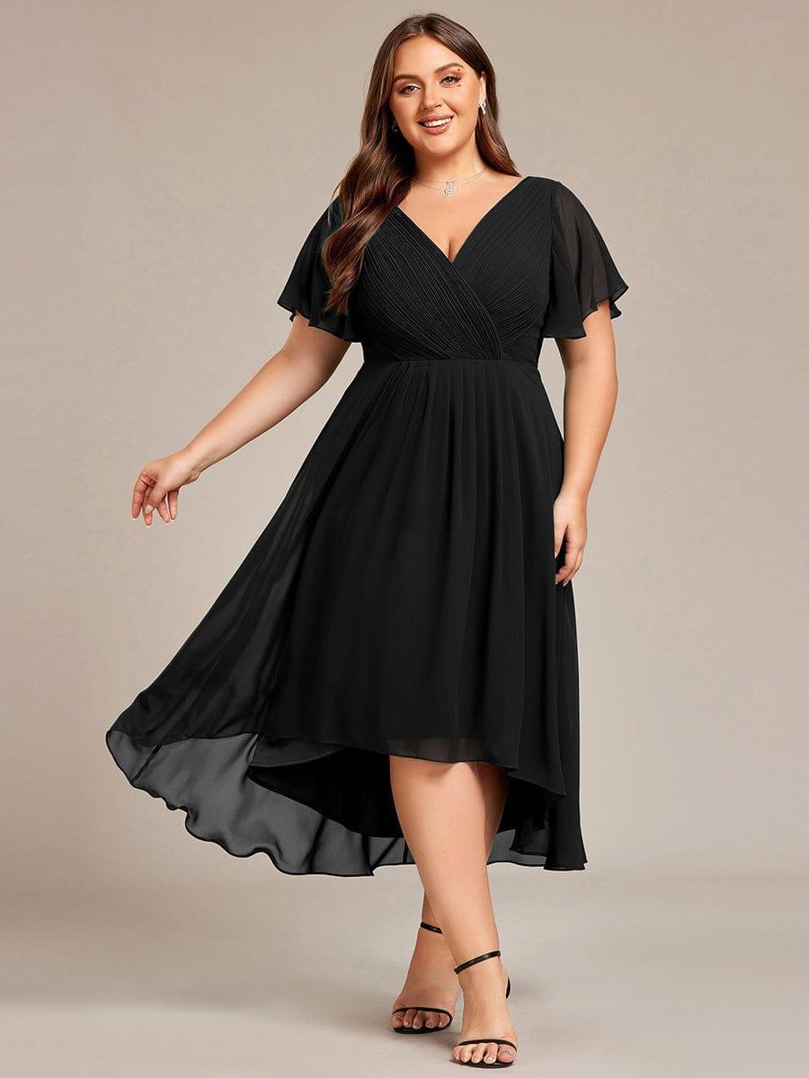 Curvy-Model im schwarzen Chiffonkleid in Frontansicht, Rock schwingt seitlich, schwarze Riemchensandalen. 26