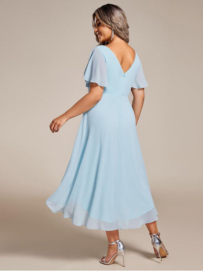 Rückansicht des hellblauen Kleids an einem Plus-Size-Model mit tiefem V-Rückenausschnitt und weit schwingendem Chiffonrock. 90