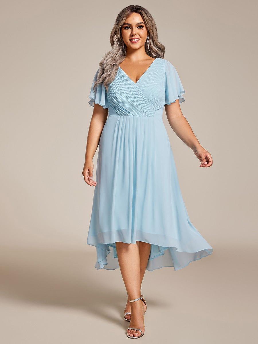 Plus-Size-Model in hellblauem Chiffonkleid mit Wickelausschnitt und Flatterärmeln, Frontansicht mit silbernen Sandalen und langen Ohrringen. 89