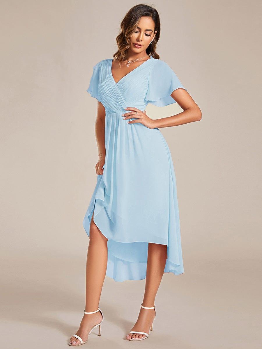 Hellblaues Chiffonkleid seitlich fotografiert, eine Hand an der Taille, der Rock wird angehoben und zeigt den fließenden Saum. 88