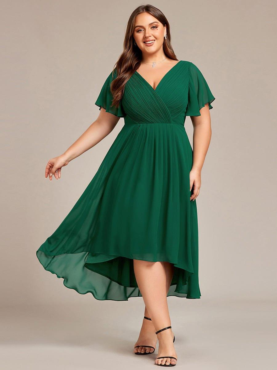 Curvy-Model im dunkelgrünen Chiffonkleid mit V-Ausschnitt und Flatterärmeln, schwingender Rock, schwarze Riemchensandalen. 36