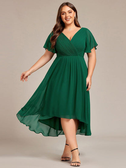 Curvy-Model im dunkelgrünen Chiffonkleid mit V-Ausschnitt und Flatterärmeln, schwingender Rock, schwarze Riemchensandalen. 36