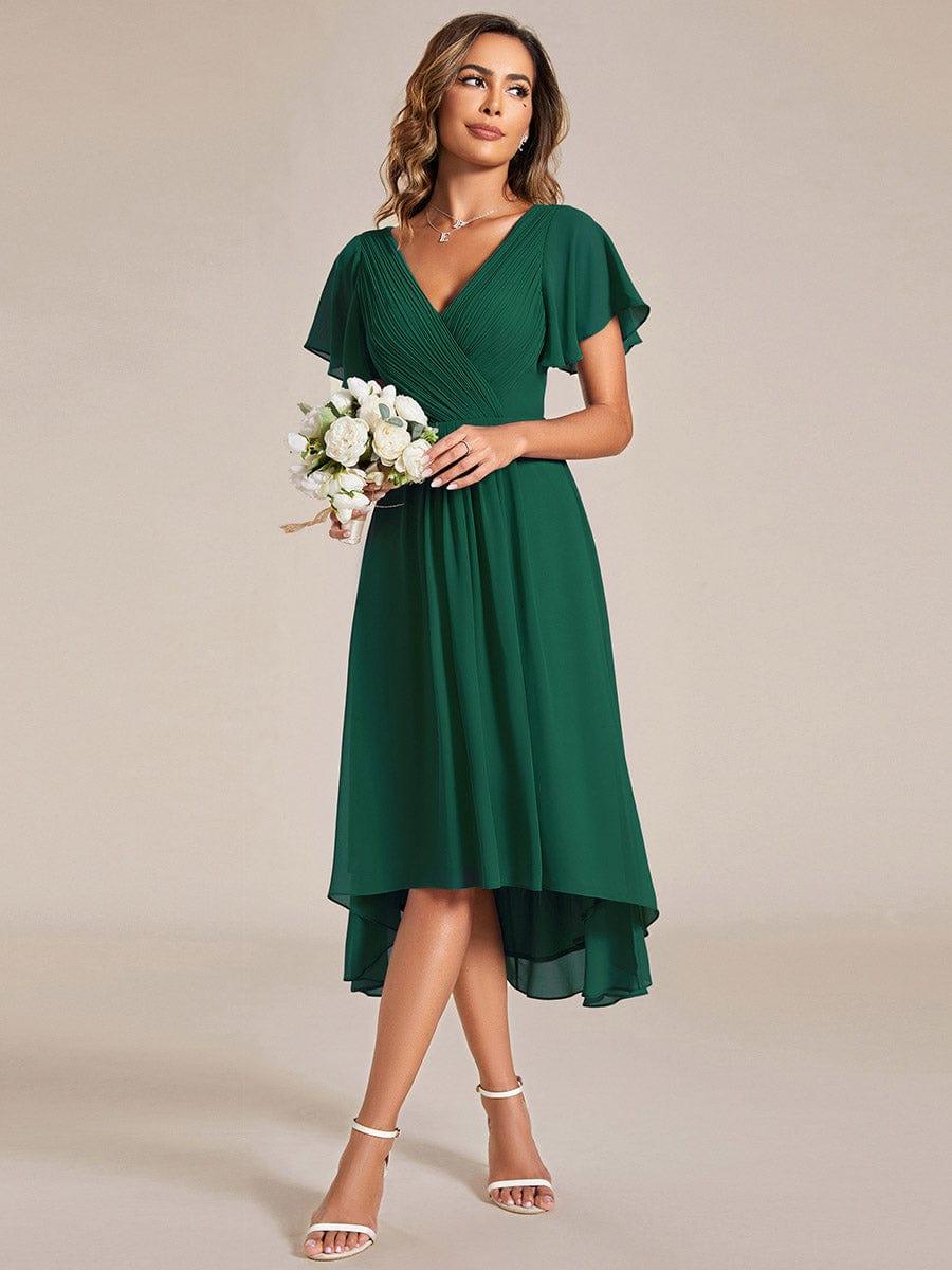 Dunkelgrünes Kleid, getragen mit einem Strauß weißer Blumen und weißen Sandaletten, Blick seitlich nach oben. 13