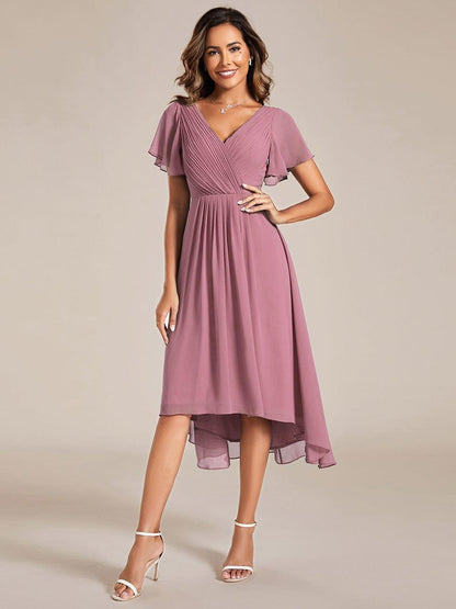 Kleid in gedecktem Altrosa frontal getragen, Hand an der Hüfte, dazu weiße Riemchensandaletten und Kette. 58