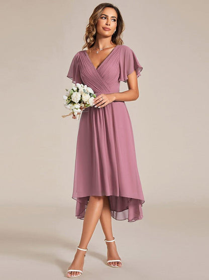 Altrosa Chiffonkleid frontal, Model hält einen kleinen Strauß weißer Blumen und blickt zur Seite. 60