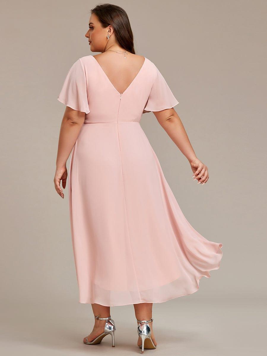 Rückansicht des rosafarbenen Kleids am Curvy-Model mit tiefem V-Rückenausschnitt, Reißverschluss und wehendem Saum. 32