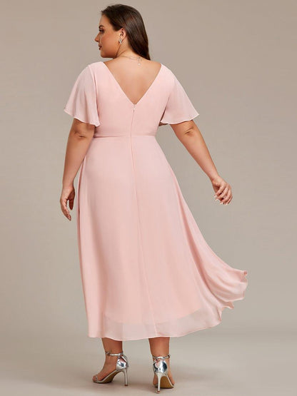 Rückansicht des rosafarbenen Kleids am Curvy-Model mit tiefem V-Rückenausschnitt, Reißverschluss und wehendem Saum. 32