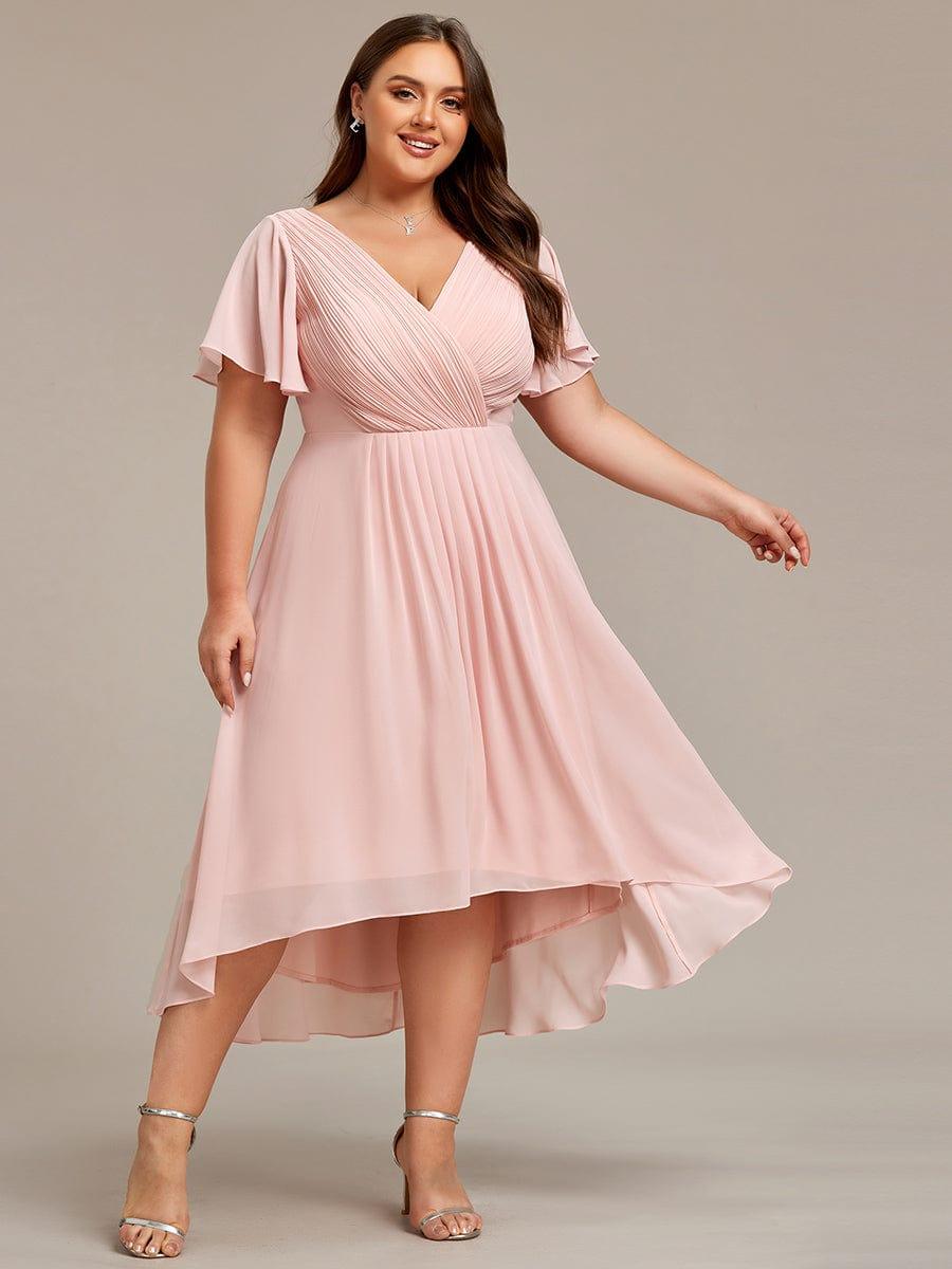 Curvy-Model im rosa Chiffonkleid in Frontansicht, Arm ausgestreckt, Rock mit asymmetrischem Hoch-tief-Saum schwingt. 34