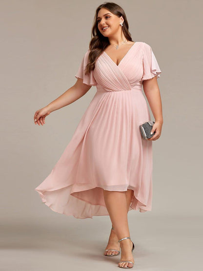 Curvy-Model im rosafarbenen Chiffonkleid mit V-Ausschnitt und Flatterärmeln, Clutch in der Hand, silberne Sandalen. 31