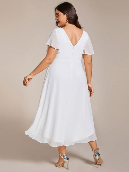 Rückansicht des weißen Kleids am Plus-Size-Model mit tiefem V-Rückenausschnitt, Reißverschluss und lang auslaufendem Chiffonsaum. 74