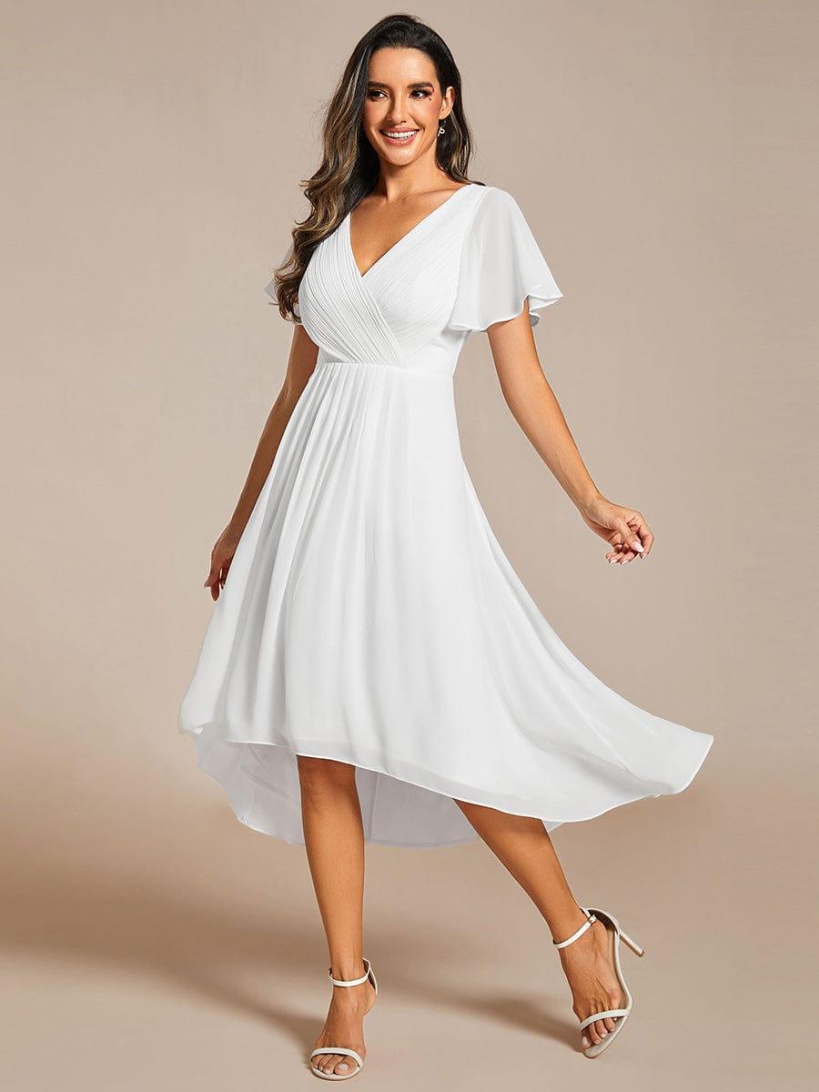 Model in weißem Chiffonkleid in Bewegung, der weite hoch-tiefe Rock fliegt zur Seite, dazu helle Riemchensandaletten. 72